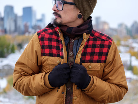 A man holds onto his trendy autumn jacket.
