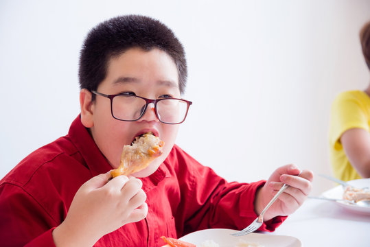 Young Asian Boy Eating Grilled Chicken At School Canteen