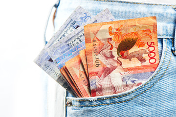 Tenge. A pack of Kazakh banknotes is in the pocket of jeans close-up..