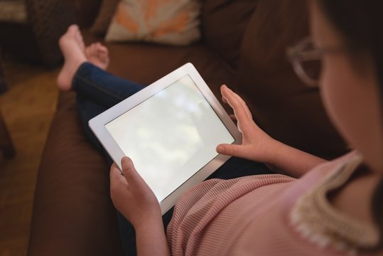 Girl using digital tablet in living room