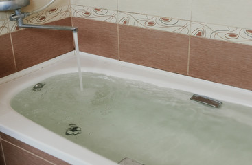 Water poured into the tub. Full bath. Close up.