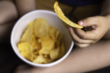 child's hand holds potato chips, concept of harmful food, fast food, obesity.