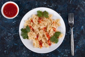 Cooked pasta with tomato sauce and greens.