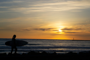 silhouette of a surfer on the beach at sunset