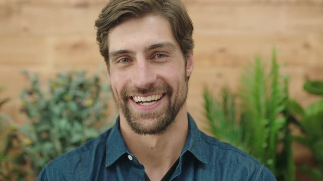 close up of attractive young man portrait of handsome caucasian guy laughing cheerful at camera