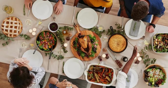 above view of young multi ethnic friends preparing table enjoying thanksgiving lunch together talking bonding over healthy meal time lapse rotate