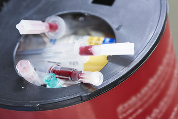 Sharp needles in biohazard container bin