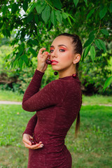 Fototapeta premium Beautiful young woman with long braid and natural cherry earrings.