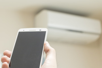 スマートフォンでエアコンを操作するイメージ