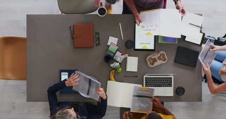 above view of multi ethnic business team brainstorming innovative ideas for startup company developing market strategy time lapse close up rotate - Powered by Adobe