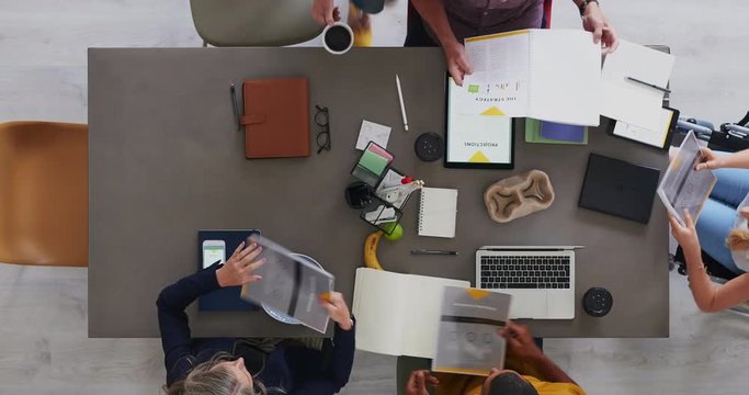 above view of multi ethnic business team brainstorming innovative ideas for startup company developing market strategy time lapse close up rotate