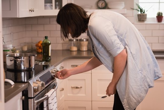 Woman using oven in kitchen