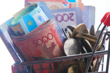 Tenge. Kazakh money in shopping cart on white background close-up..