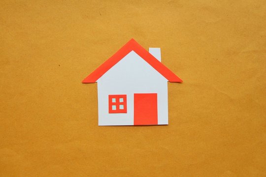 Paper cut of house red roof on brown background,top view. 