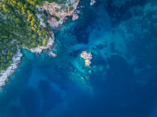 Stafilos beach on the island of Skopelos. Offshore viewing the coastline with beautiful aqua water and coral reef from the air.