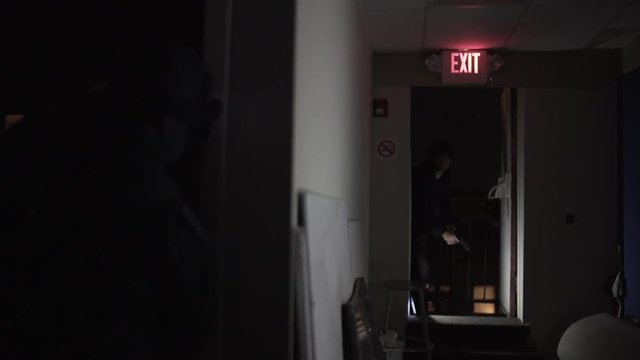 A shootout between two men in a hallway.