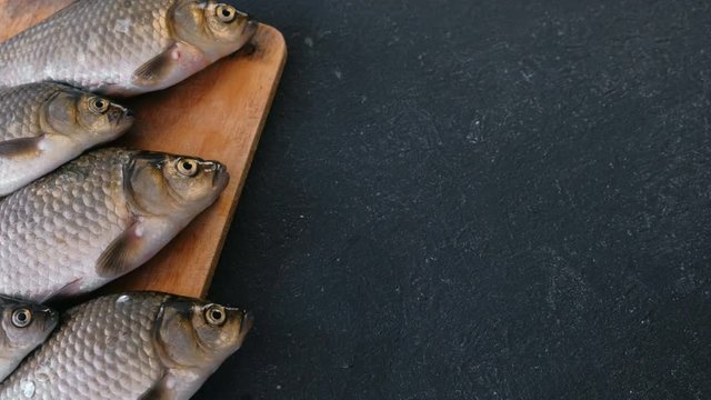 Cooking fish. Fresh small carps on the table on a wooden Board close-up.
