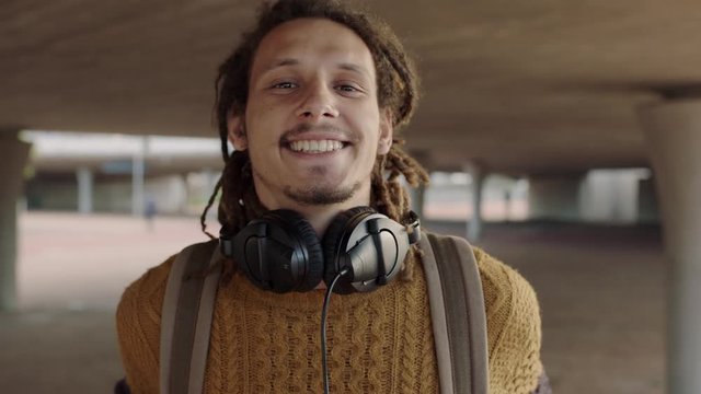portrait of attractive young hippie student man smiling confident wearing headphones