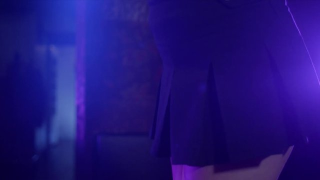 Tilt up on sexy woman doing a slow seductive dance at a club