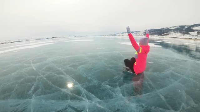 Girl is training practice yoga in winter. Woman is do stretching and meditation on ice in nature. Athlete practices yoga on beautiful with cracks ice. Woman do sport fitness in outdoor. Background