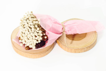 Closeup of bouquet dried white Eriocaulon henryanum Ruhle on round teak wood.