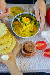Vegetable corn soup with turmeric powder. Hot and spicy soup. Vegetarian lunch or vegan dinner with carrot and potato. Served with Indian traditional garlic naan flat bread or chapati (roti).