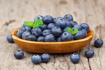 Blueberries in a wood bowl on a wooden table, Healthy eating and nutrition concept