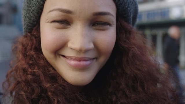 close up portrait of beautiful mixed race woman frizzy hair smiling happy looking at camera