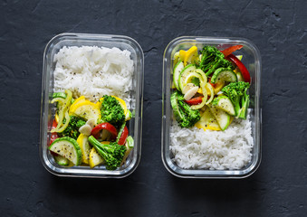 Vegetarian lunch box - stewed vegetables and rice on a dark background, top view. Health food...