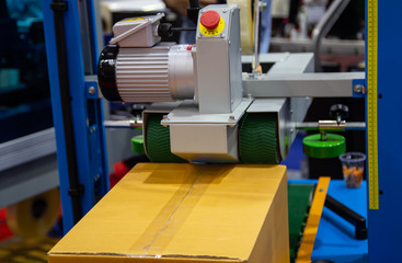 Automatic carton, cardboard tape sealing machine. Industrial logistics warehouse