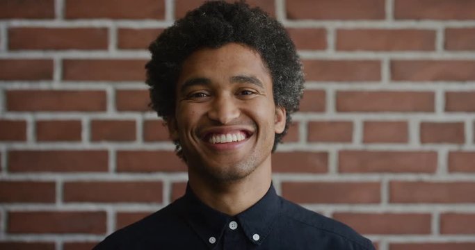 portrait happy young mixed race man smiling cheerful independent male enjoying lifestyle success afro hairstyle slow motion