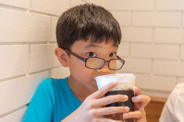  young boy drink milk in glass.