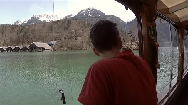 A boy drives a boat in Konigsee.
