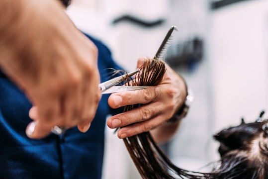 Close-up image of hairdresser cutting hair.