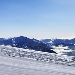 Ski slope and snowy mountain in haze