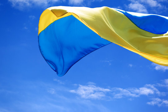 Sunlight flag of Ukraine waving on blue sky