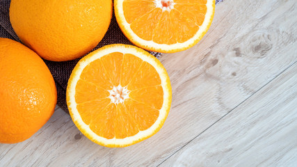 Oranges fruit in a basket on a wooden table.
