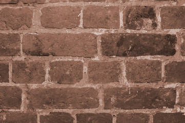 A toned background of a piece of brick wall closeup inside an antique antique house. Background, texture