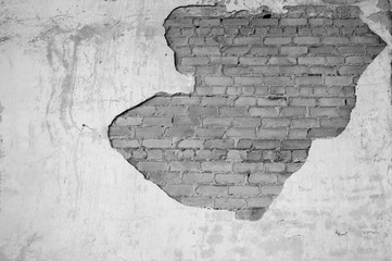 Wall with partially removed plaster in the form of figured drawing of a brick texture. Background. Black and white image