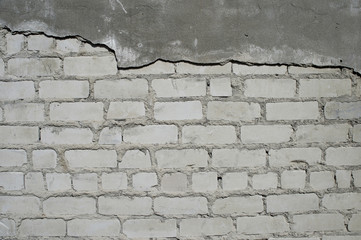 Wall with partially removed plaster in the form of figured drawing of a brick texture. Background