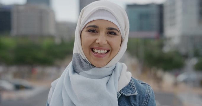 portrait young beautiful muslim woman laughing enjoying successful urban lifestyle independent female student wearing hijab headscarf in city wind blowing