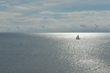 Sailboat on the smooth surface of the sea