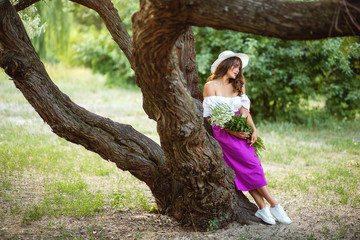 A serene girl with a bouquet of flowers enjoys nature