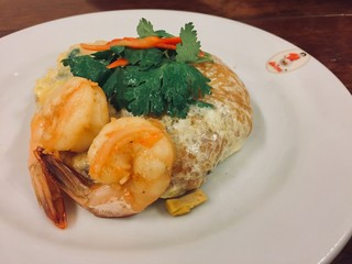 Top view of a Shrimp Pad Thai, traditional Thai dish with stir fried rice noodles with big shrimps, you can try to eat Pad Thai on the street in Bangkok, Thailand, Street food of Bangkok, Thailand