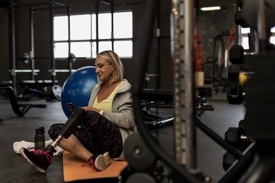 Mature woman using mobile phone in the gym