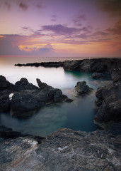 Plakat Stones in the sea on a long exposure during sunset.
