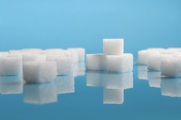 selective focus Group of Sugar cubes vary position on light blue background