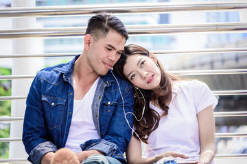 Asian couple tourist have music listening together.