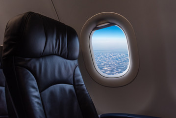seat and plane window with beautiful blue sky.