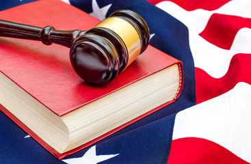 Gavel with law book on american flag. Close up.
